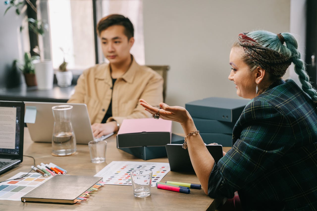 Two coworkers engaged in a productive strategy meeting at a modern office desk.